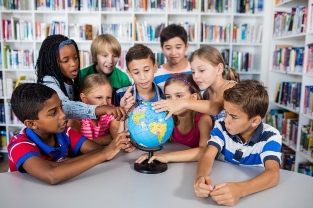 Students exploring globe in library